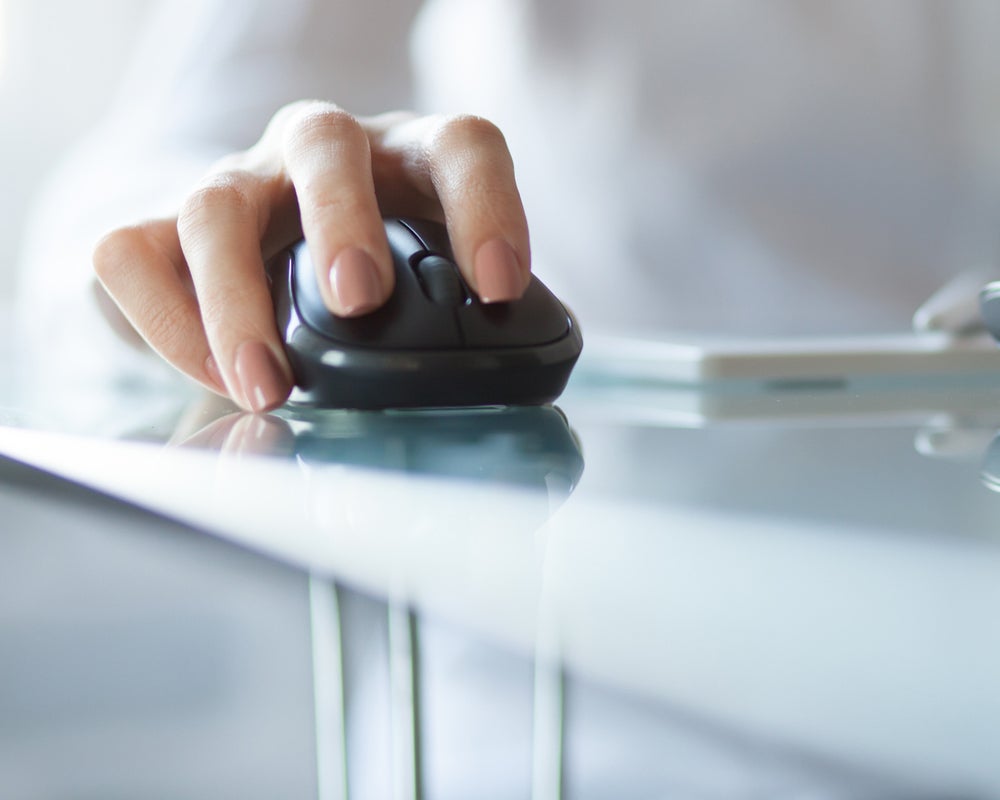 Businesswoman clicking on cordless mouse
